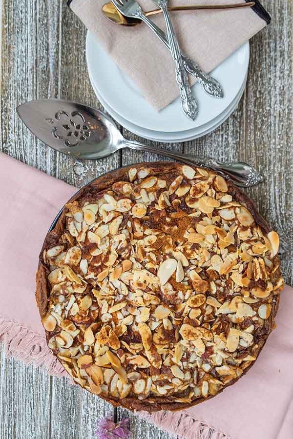 top view of apple sponge cake with serving spoons and small plates