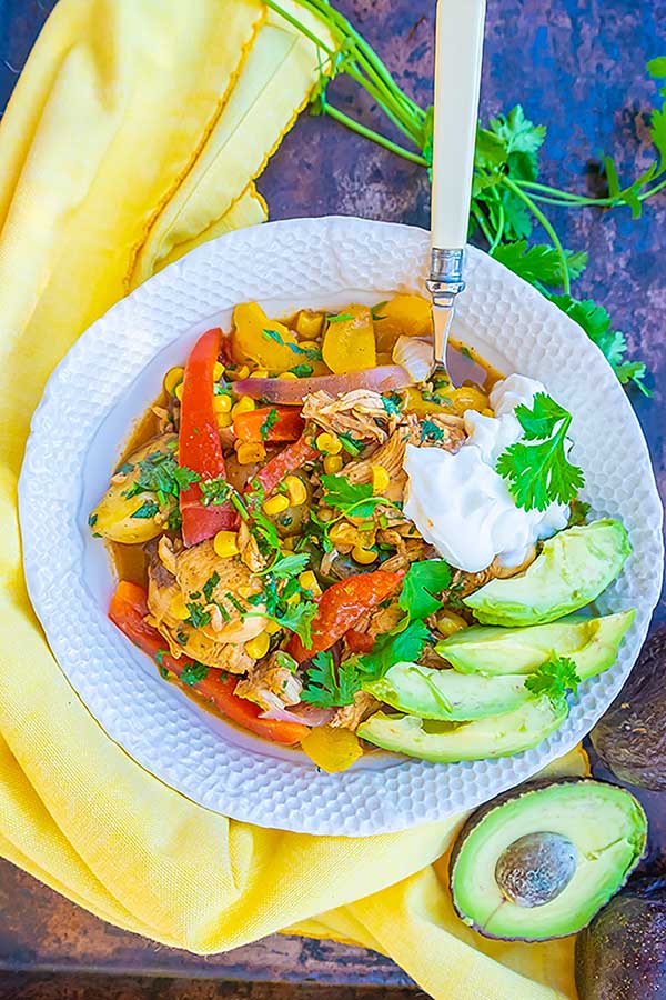 chicken fajita stew in a bowl with avocado and sour cream 