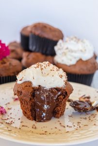 chocolate filled cupcake topped with frosting on a plate