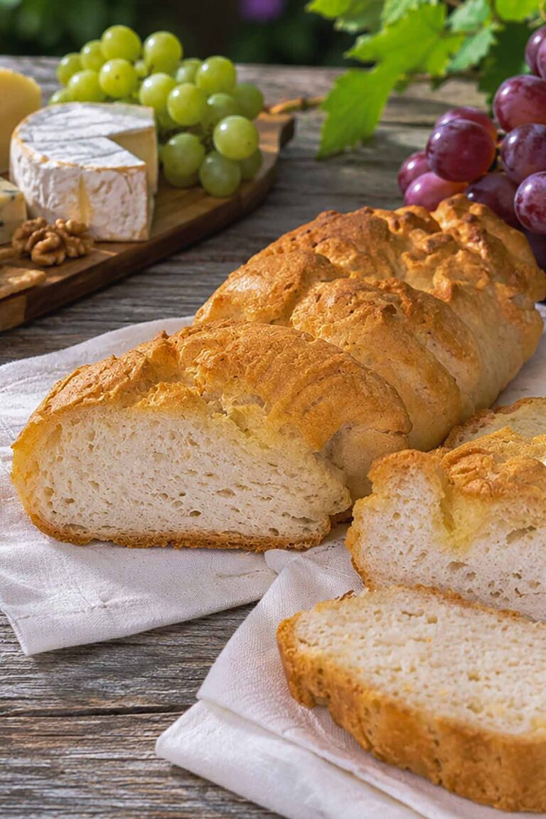 French baguette bread sliced showing crispy outside and soft on the inside with cheese in the background