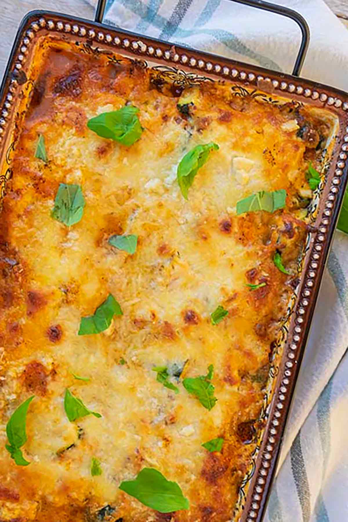 Italian gluten free & low carb zucchini layered with tomato sauce and 3 cheeses in a baking dish