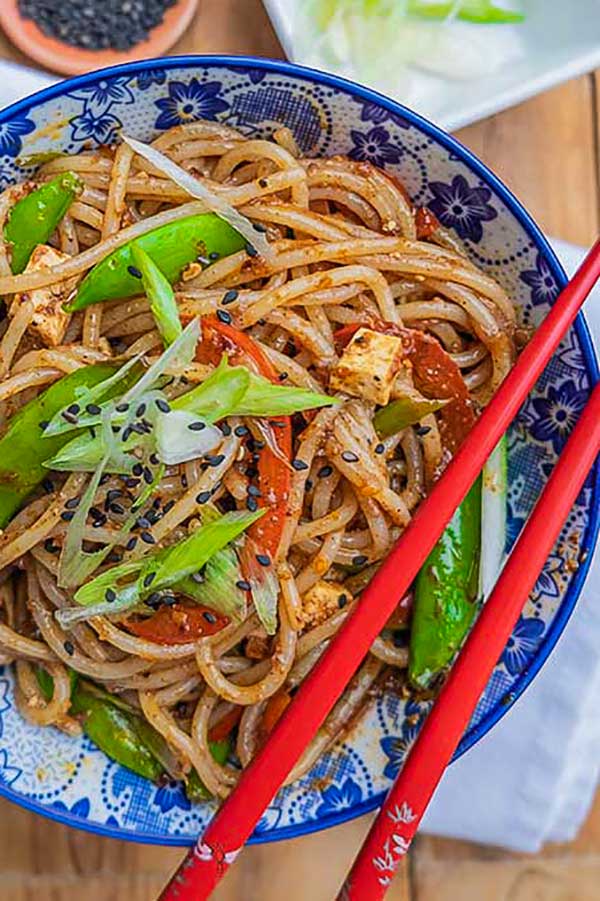 chinese noodles with snow peas in a bowl