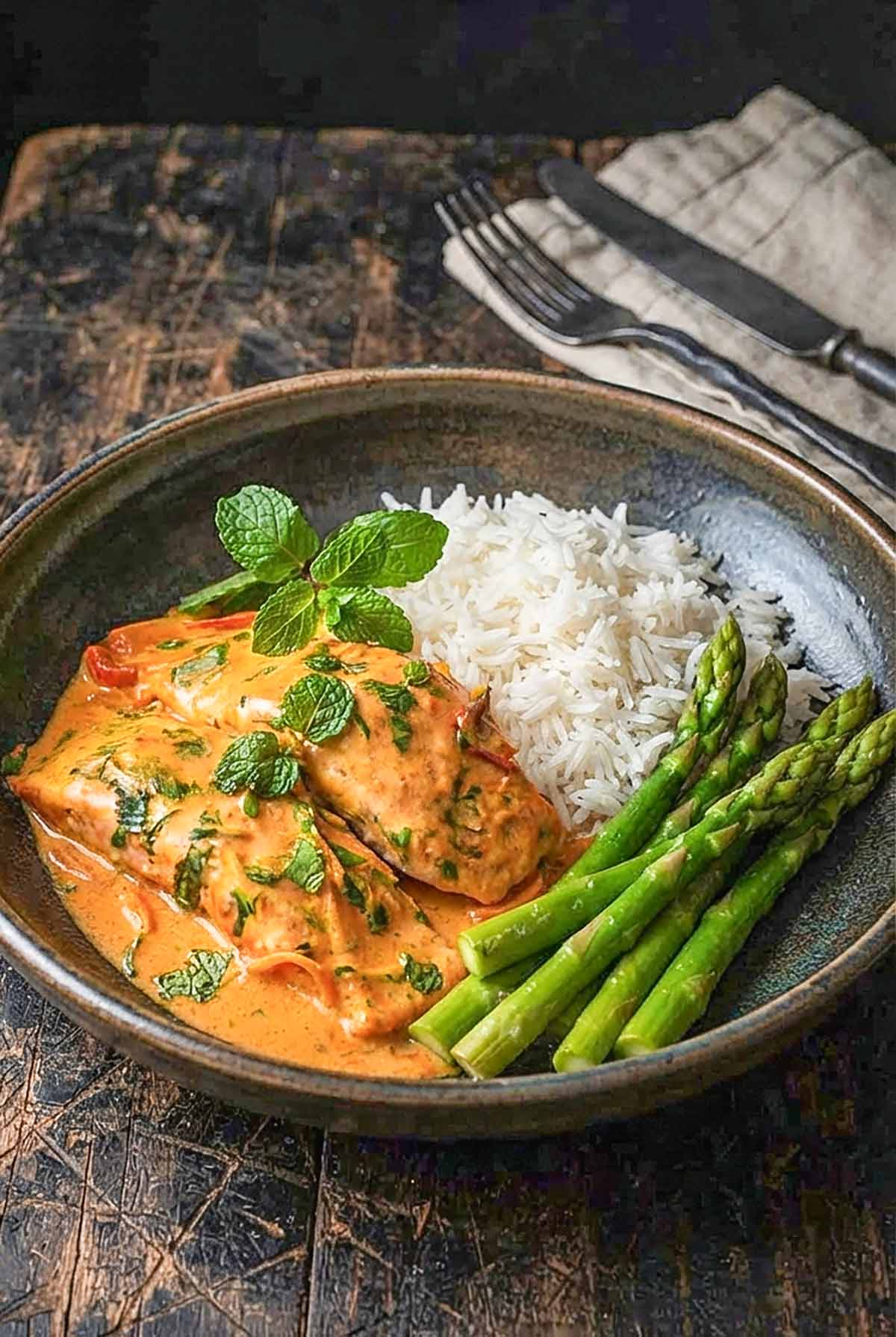 Thai Coconut Cream Salmon in a bowl with rice and steamed asparagus