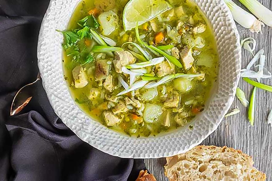 peruvian chicken soup in a bowl with crusty bread