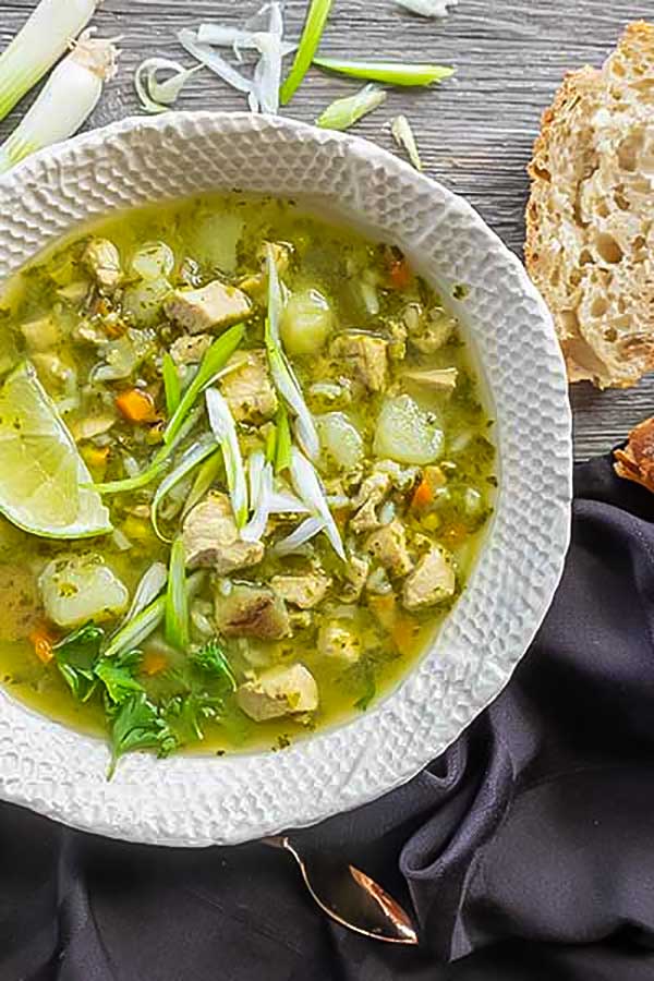 peruvian chicken soup in a bowl with crusty bread