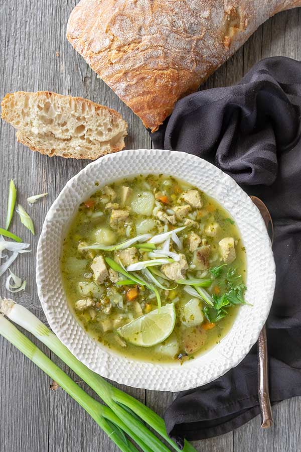 Peruvian chicken soup in a bowl with sliced bread