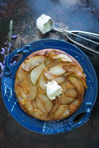 pear dutch baby on a blue plate, gluten free.