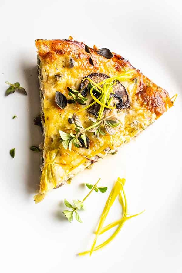 slice of crustless quiche with leeks mushrooms and fontina on a plate