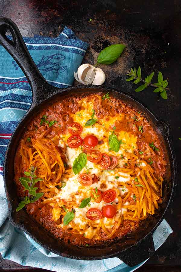 overview of bake pasta topped with cheese in a cast iron skillet