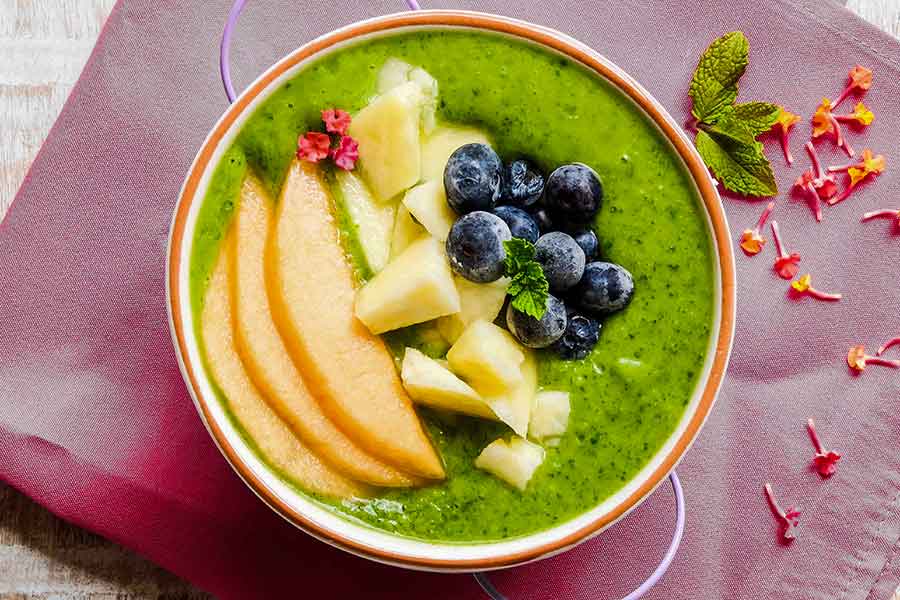 dairy free pineapple smoothie bowl topped with fruit