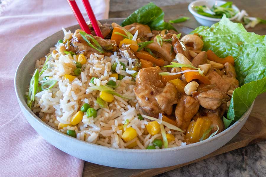 gluten-free Kung Pao Chicken with rice in a bowl with chopsticks