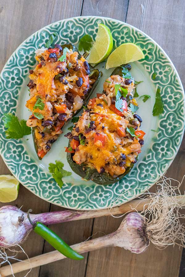 2 stuffed poblano peppers with cheesy chicken on a plate