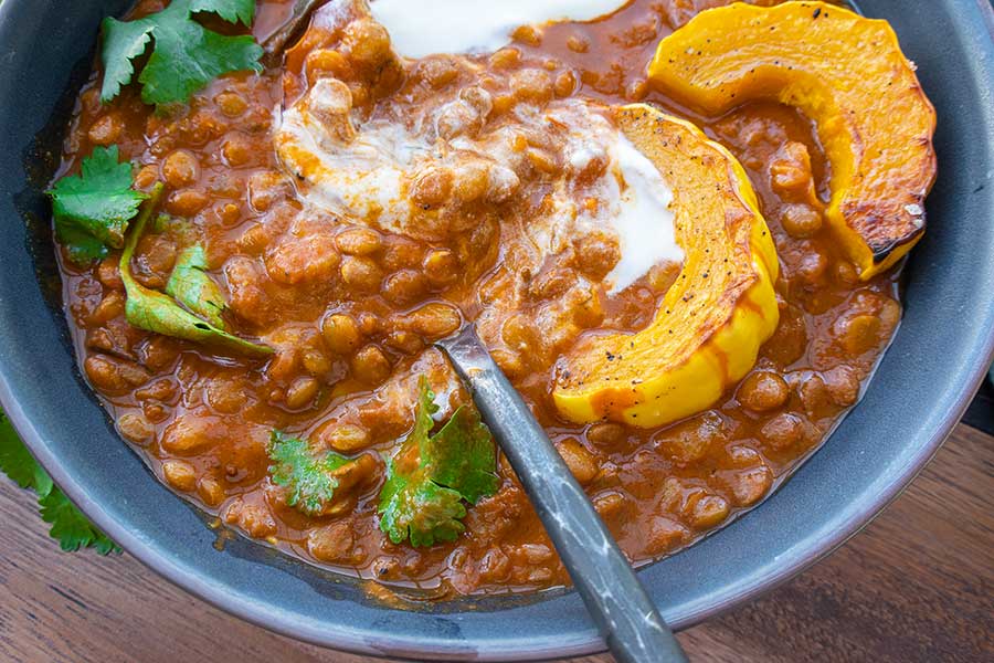 vegetarian recipe of creamy lentils topped with roasted squash in a bowl