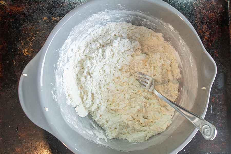 shortcrust pastry ingredients mixed with a fork in a bowl