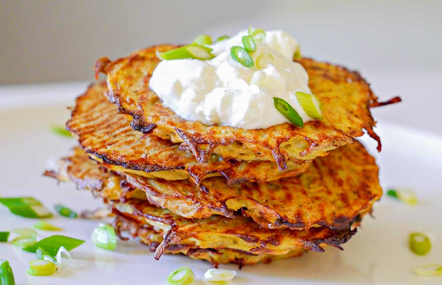 stack of potato pancakes topped with sourcream, a vegetarian recipe
