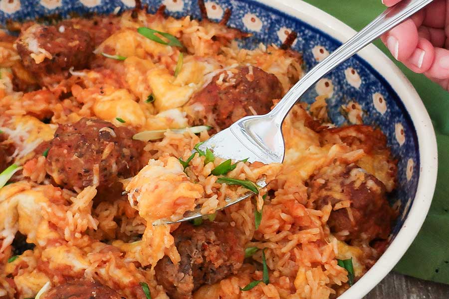 a fork in a meatball and rice dish