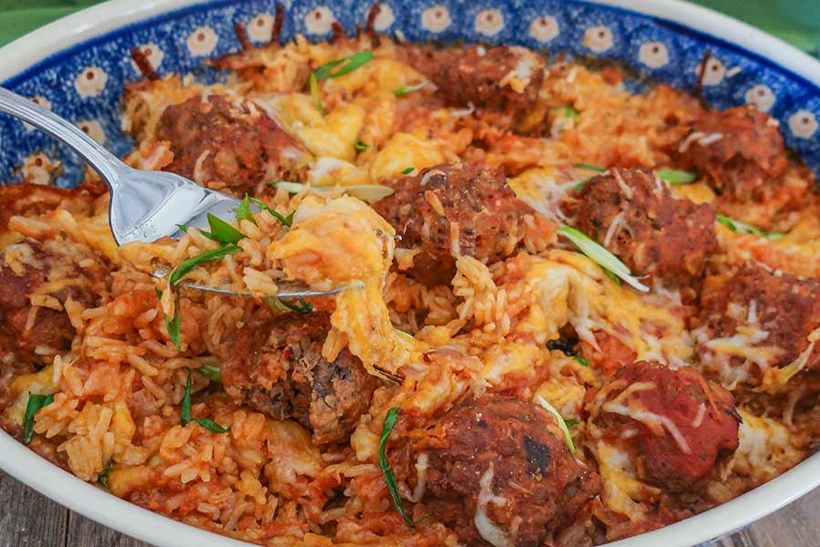 close up of a casserole dish with rice and meatballs