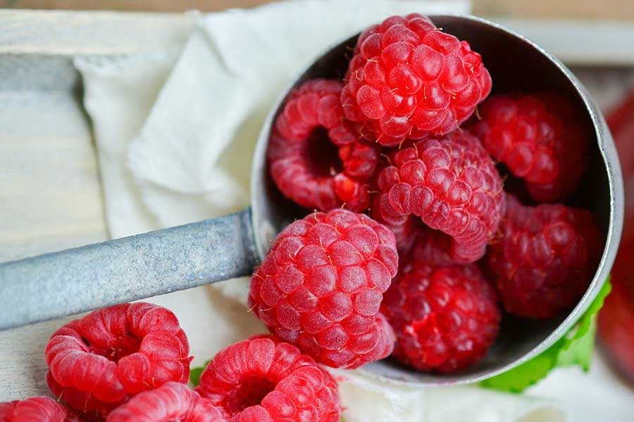 fresh raspberries in a measuring cup