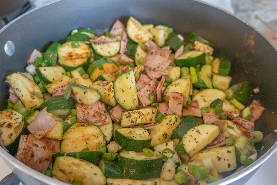 veggies and ham in a skillet with spices