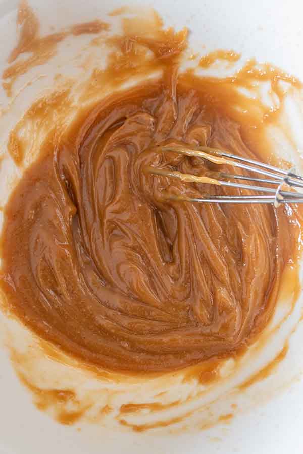 whisking almond butter caramel in a bowl