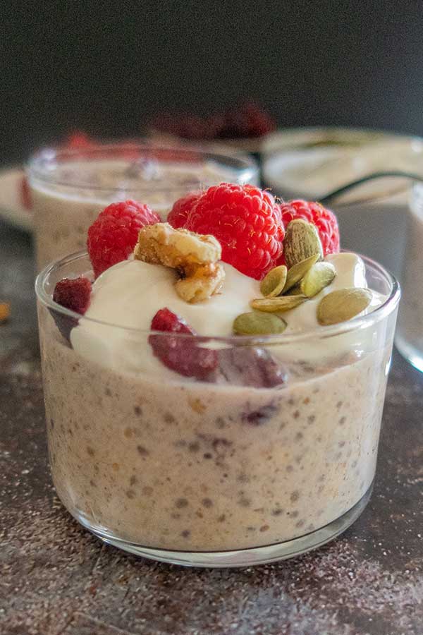 a glass filled overnight oats and fruit.