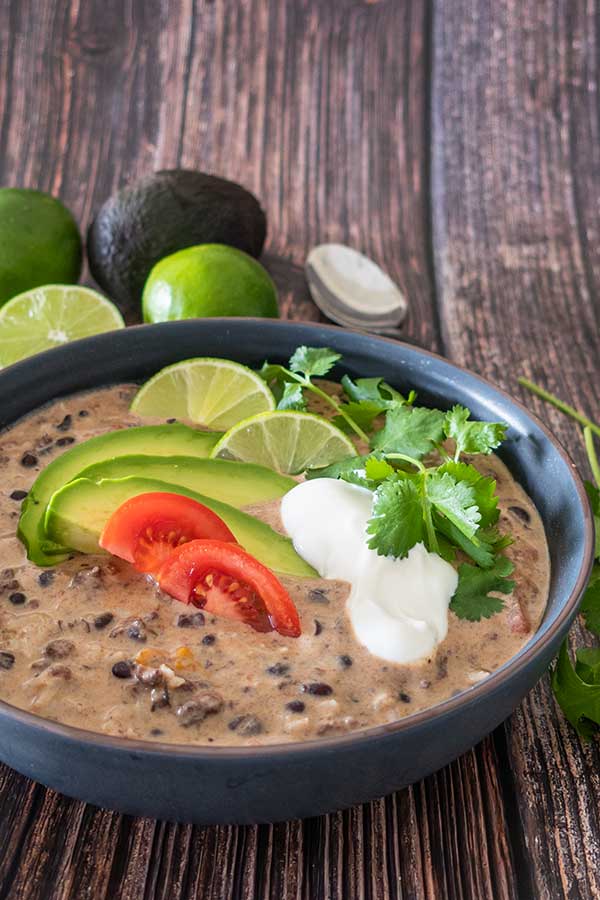 tex-mex soup in a bowl with avocado and limes