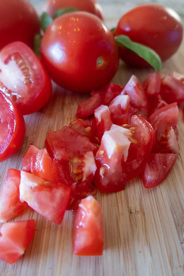 chopped cherry tomatoes on a cutting board