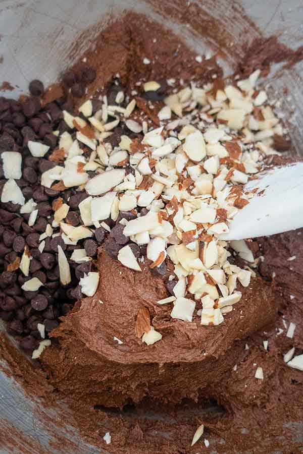 brownie cookie dough with sliced almonds in a bowl with spatula