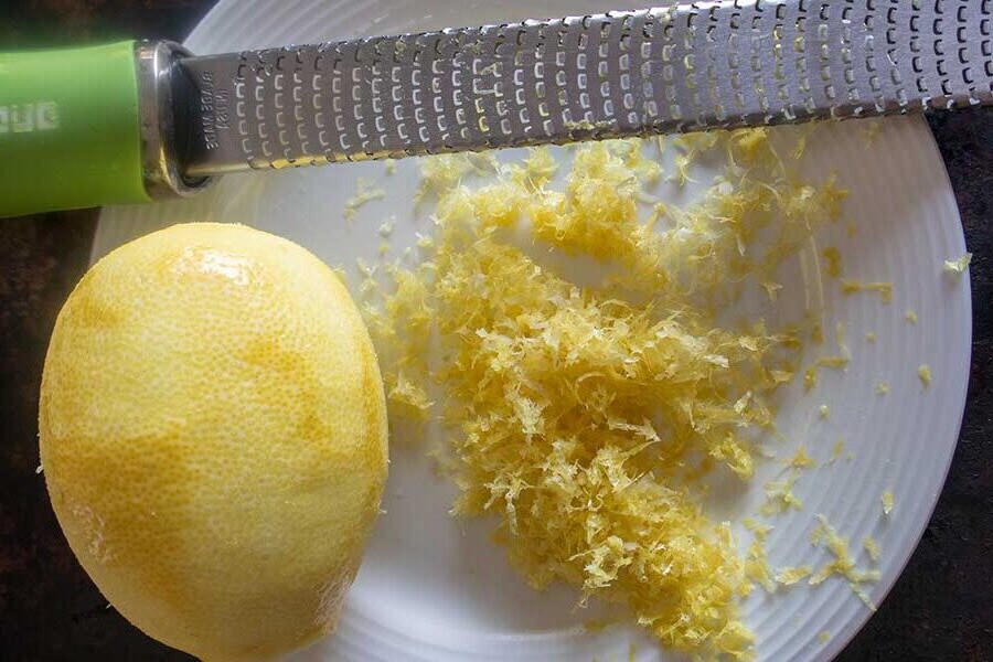 Zesting a lemon using a microplane for fresh citrus flavor 