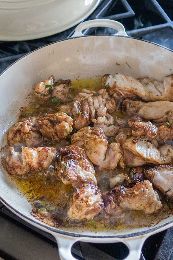 chicken cooking with herbs in olive oil