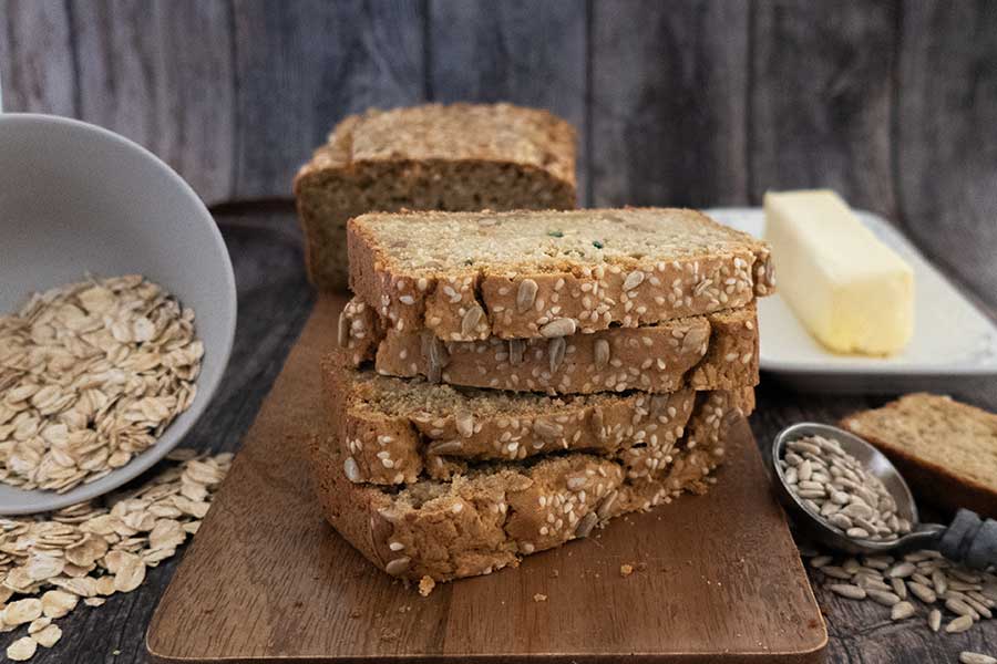 sliced oat flour bread with butter on a cutting board