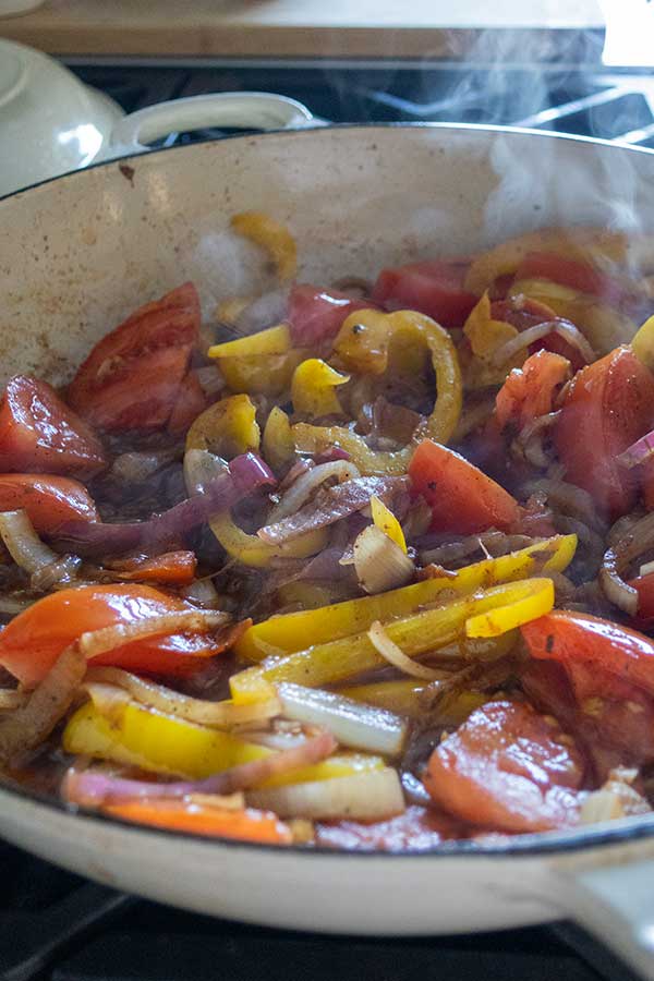 onions tomatoes peppers cooking in olive oil