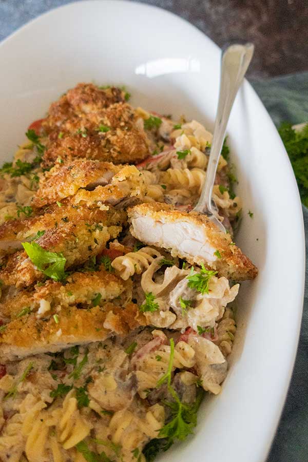 Louisiana Style Crispy Parmesan Chicken Pasta in a serving dish with a fork