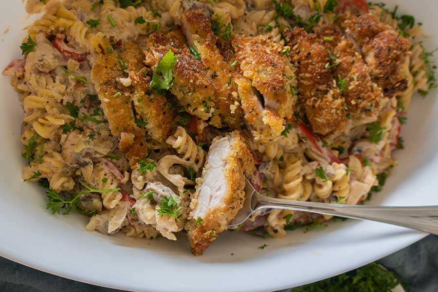 parmesan chicken over pasta on a plate