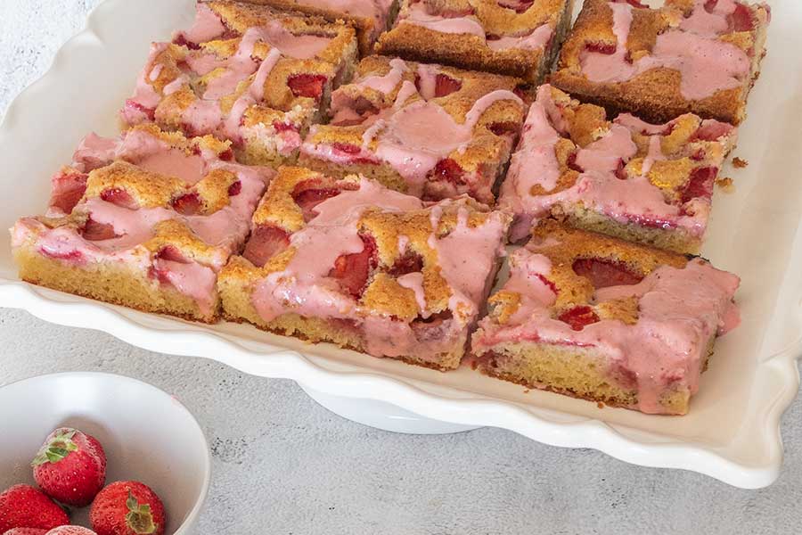 strawberry sheet cake sliced into squares