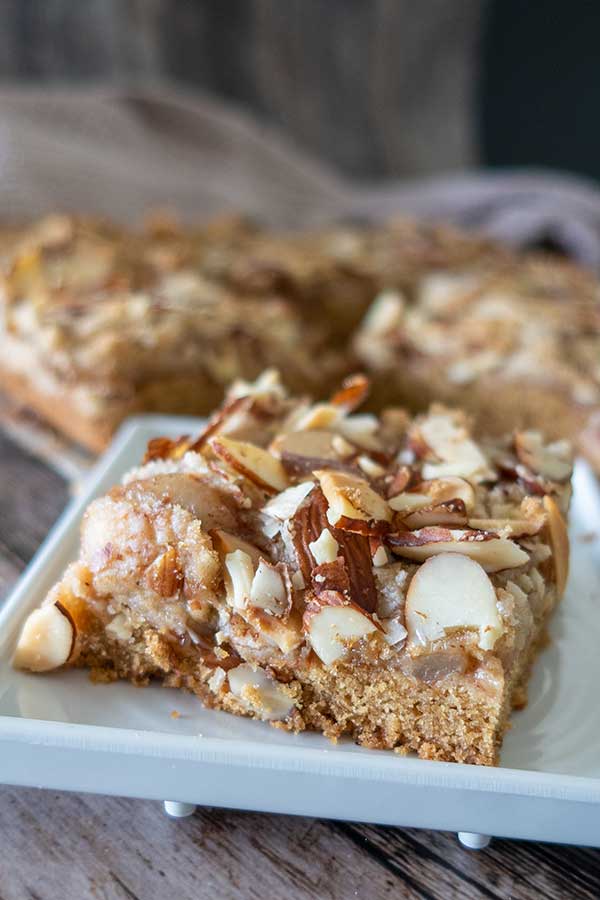 close up of a single slice baked gluten-free apple pie bar on a white dessert plate