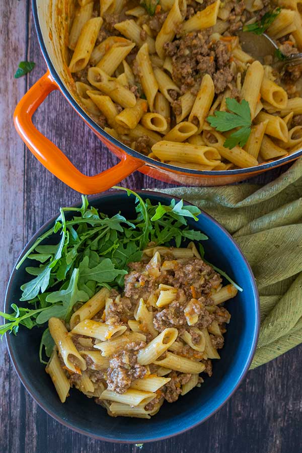 hamburger helper with pasta in a bowl topped with parmesan