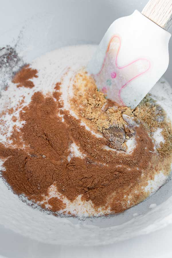 rice flour, coconut milk, and spices in a bowl with a spatula