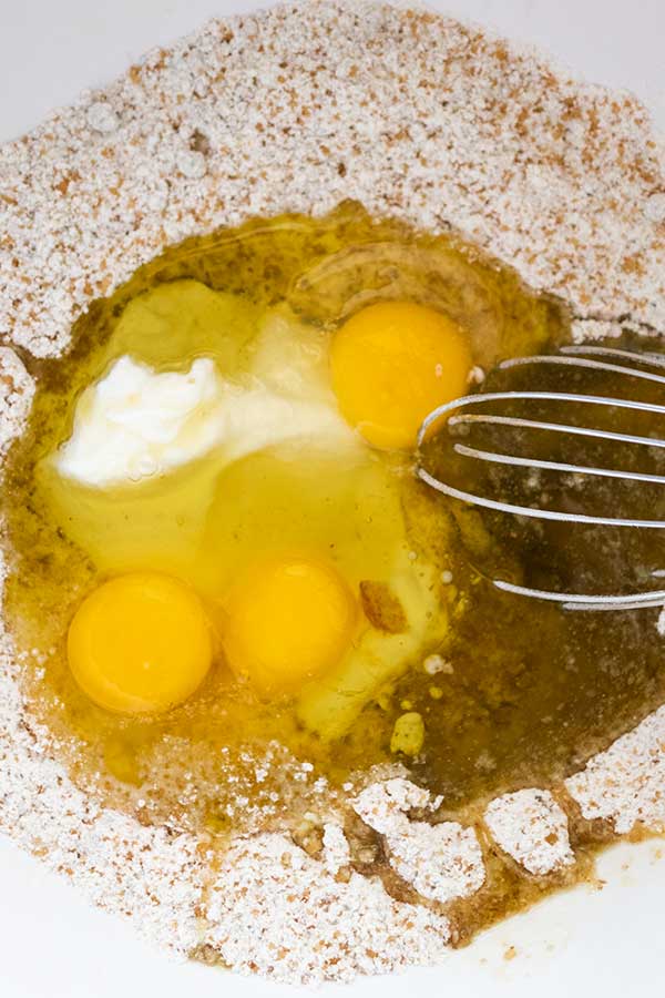 flour eggs olive oil sugar and yogurt in a bowl