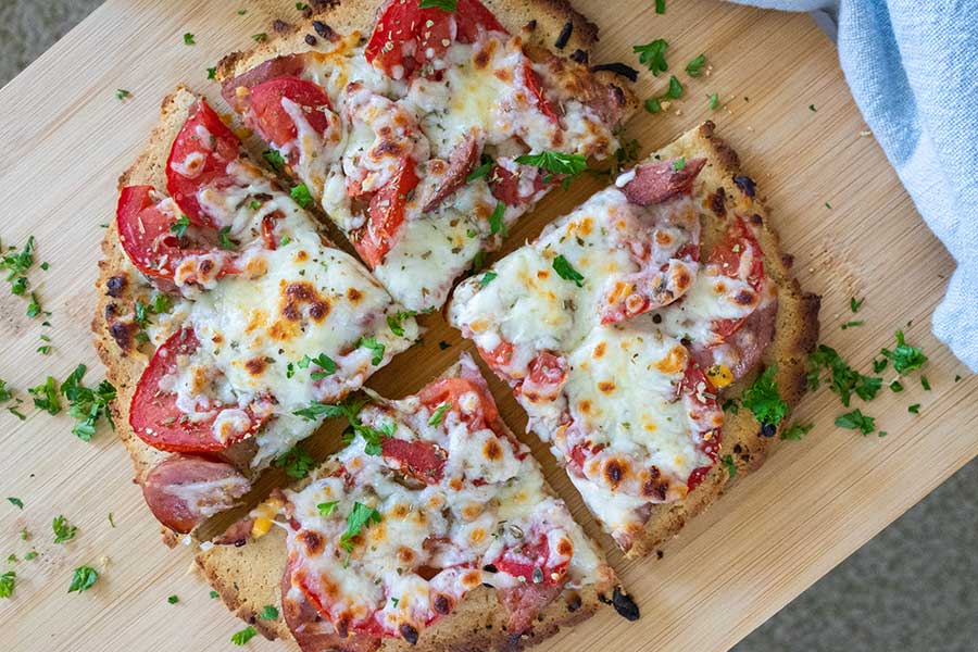 sliced keto pizza for one on a cutting board