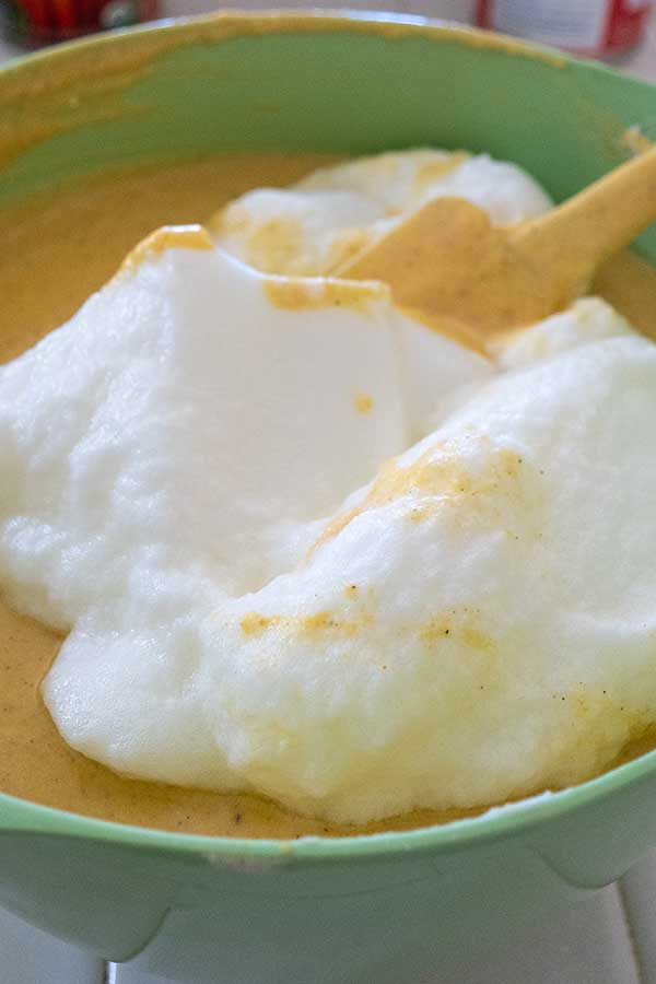 whipped egg whites added to cake batter in a bowl