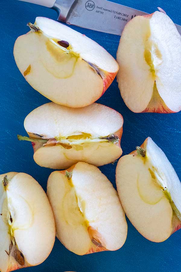 quartered apples on a cutting board