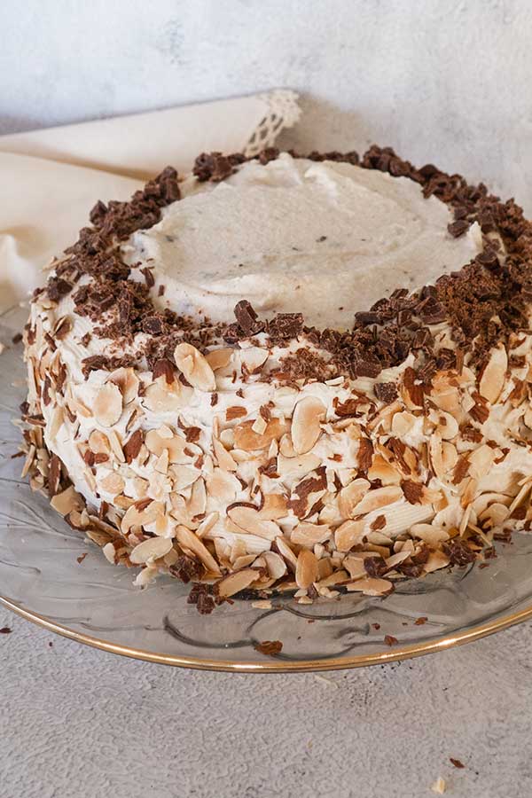 gluten free cannoli cake decorated with frosting, almonds and chocolate