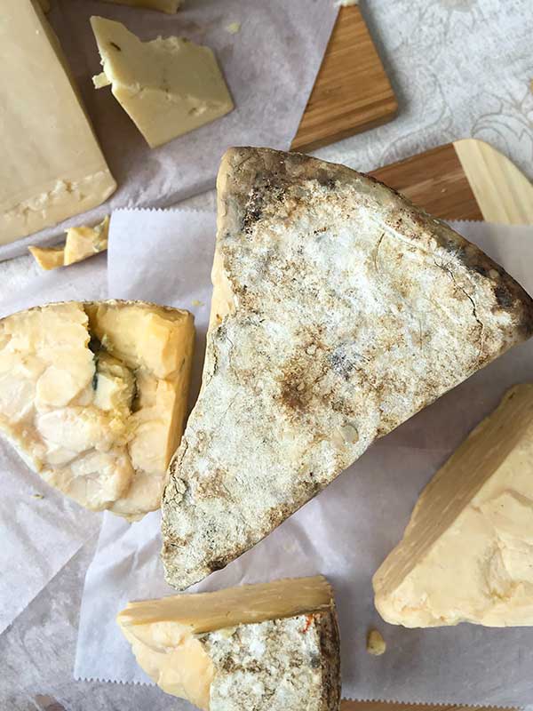 4 various cheeses on a cutting board