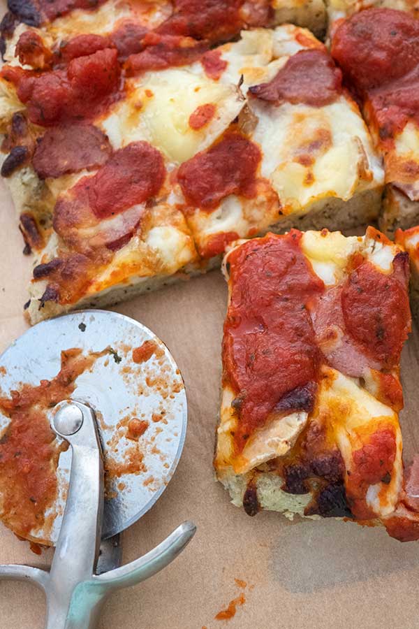 gluten free slice of detroit style pizza with pizza cutter