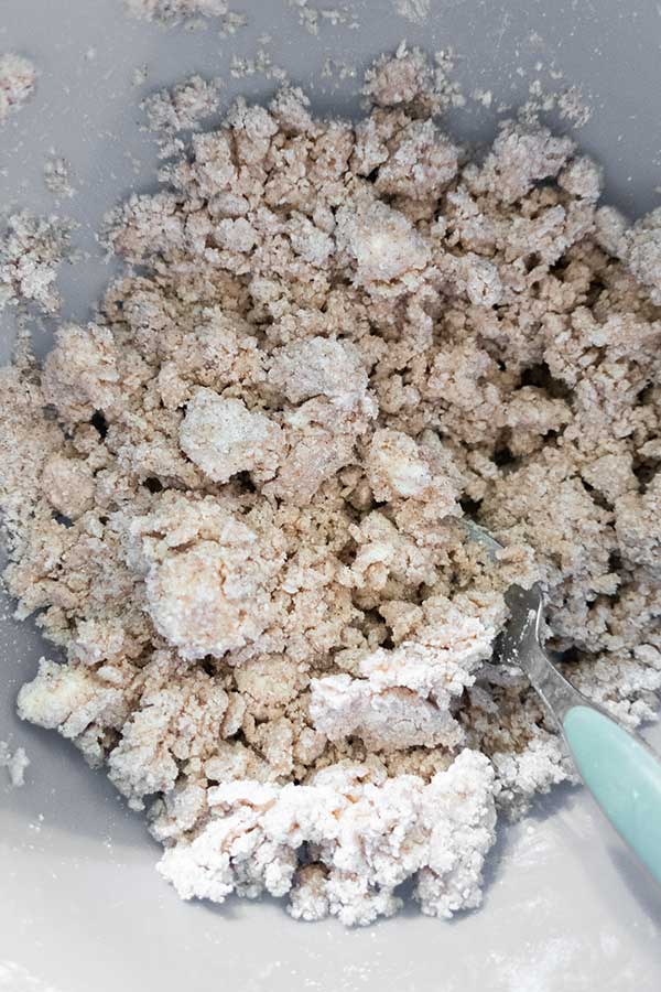 lumps of dough for crumb bars in a bowl with a fork