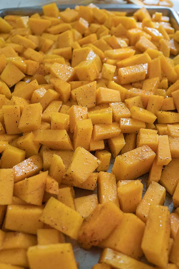 seasoned butternut squash cubes on a baking tray