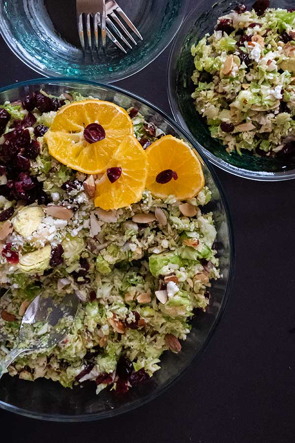 brussels sprouts salad with cranberries in a salad bowl and serving bowls