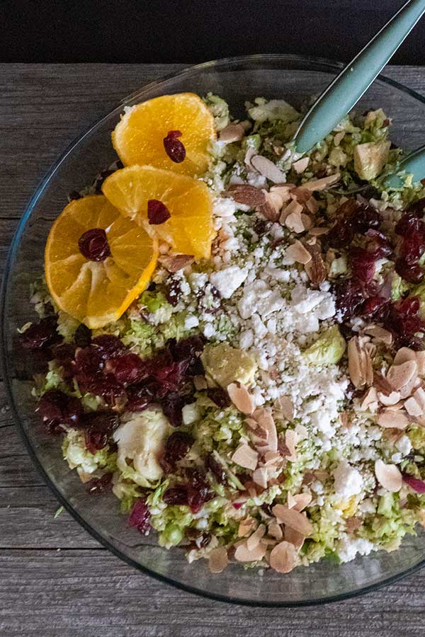 overview of brussel sprouts, oranges, cranberries, feta and almonds in a bowl