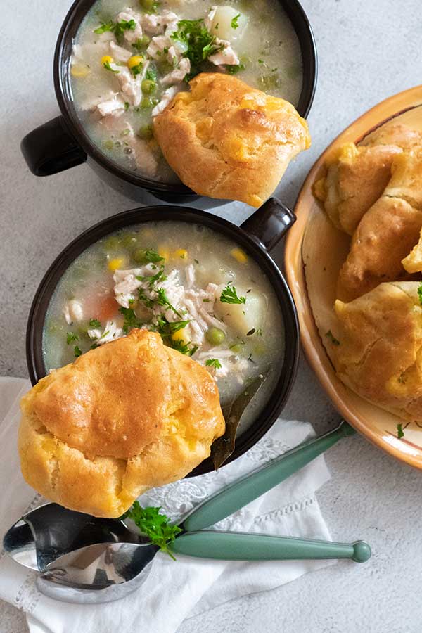 2 cups filled with creamy soup topped with biscuit